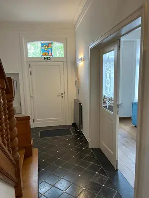 a hallway with a door with a stained glass window at Sint-Catharina in Lier