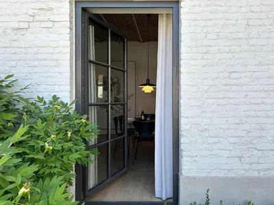 a sliding glass door leading to a dining room at Hyggehus Tervuren in Tervuren
