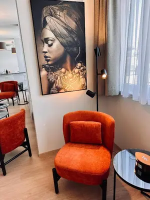 a living room with a chair and a painting on the wall at Penthouse Grand Place - 2bd - 200sqm Terrace in Brussels