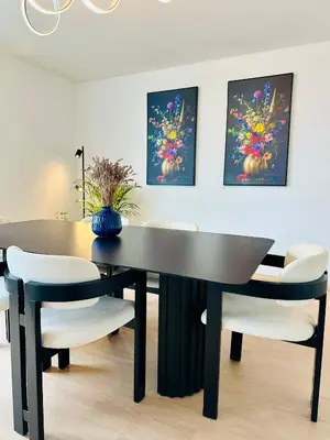 a dining room with a black table and white chairs at Grand Place View - 2bd - Exclusive Apartment in Brussels