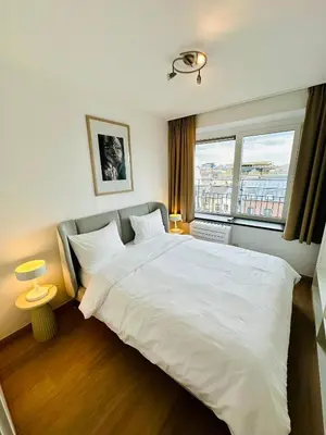 a bedroom with a large white bed with a window at Grand Place View - 2bd - Exclusive Apartment in Brussels