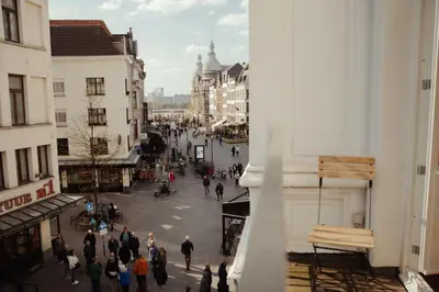 a group of people walking down a city street at A Place Antwerp - Boutique Suites & Flats - Oude Koornmarkt 1 in Antwerp