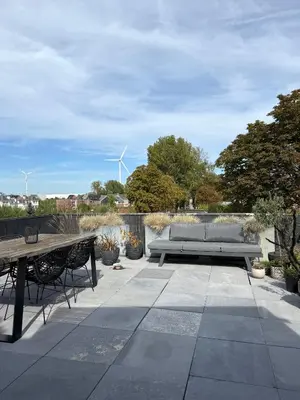 a patio with a bench and a table and windmills at Dakappartement V, 2de verdiep TML in Willebroek