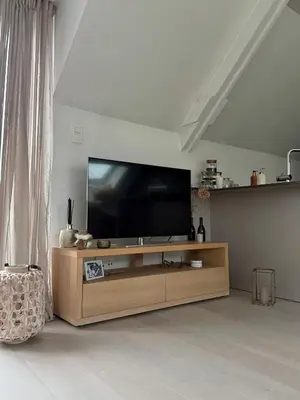a flat screen tv sitting on top of a wooden entertainment center at Dakappartement V, 2de verdiep TML in Willebroek