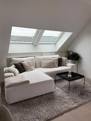 a living room with a couch and a skylight at Dakappartement V, 2de verdiep TML in Willebroek