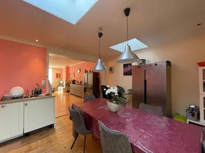 a kitchen and dining room with a table and a refrigerator at Nyumbani Stays in Boom