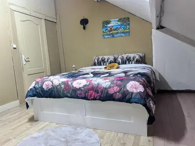 a bedroom with a bed with a floral bedspread at Nyumbani Stays in Boom