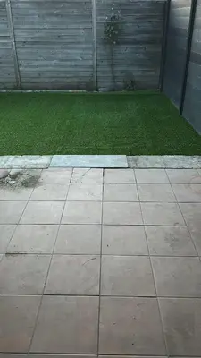 a patio with a yard of grass and a garage at Nyumbani Stays in Boom