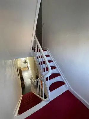 a white staircase with a red floor and red carpet at Nyumbani Stays in Boom