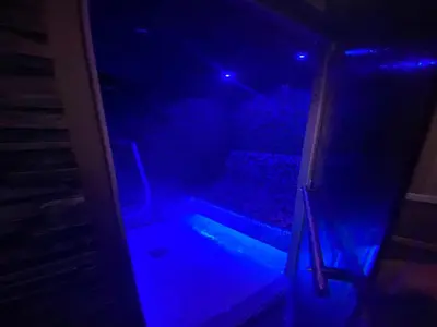 an empty room with blue lights in the dark at Majestic Wellness Center in Brussels