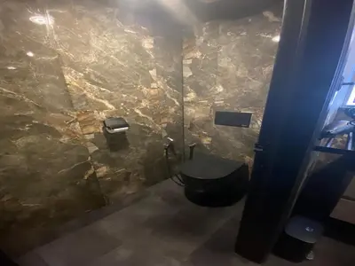 a bathroom with a toilet and a stone wall at Majestic Wellness Center in Brussels