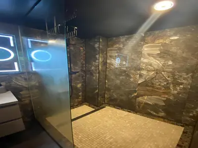 a shower in a room with a stone wall at Majestic Wellness Center in Brussels