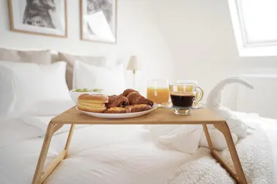 a tray of pastries on a table on a bed at Penthouse with a Neo-Gothic Parish church view in Ghent