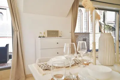 a dining room table with wine glasses on it at Penthouse with a Neo-Gothic Parish church view in Ghent
