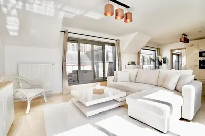 a living room with a couch and a table at Penthouse with a Neo-Gothic Parish church view in Ghent
