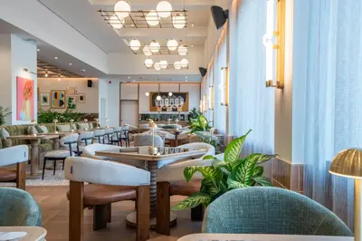 a restaurant with tables and chairs and plants at Via Antwerp in Antwerp