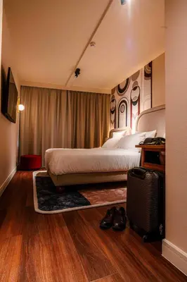a hotel room with a bed and a suitcase at Via Antwerp in Antwerp
