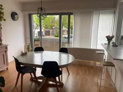 a dining room with a table and chairs and a kitchen at Modern & Cozy Apartment near Tomorrowland- Sleeps 4 in Edegem