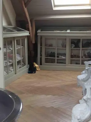 a room with glass cabinets and a cat sitting on the floor at The Secret Garden in Lankom