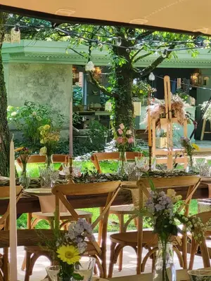 a wooden table with flowers in vases on it at The Secret Garden in Lankom