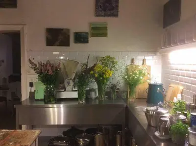 a kitchen counter with vases of flowers on it at The Secret Garden in Lankom