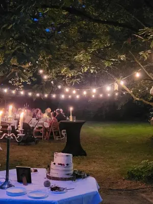 a group of people sitting at a table with a cake at The Secret Garden in Lankom