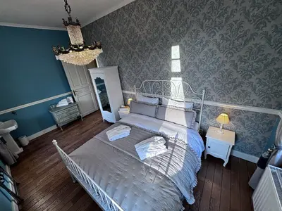 a bedroom with a bed and a blue wall at Le Manoir des Etangs in Etbos