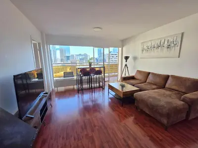 a living room with a couch and a large window at Bxl central with city views in Brussels