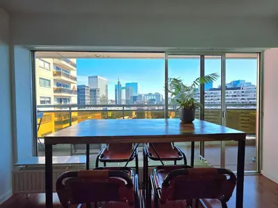 a table with chairs in front of a large window at Bxl central with city views in Brussels