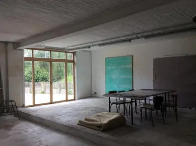 an empty room with a table and chairs and a screen at The Secret Garden in Herentals