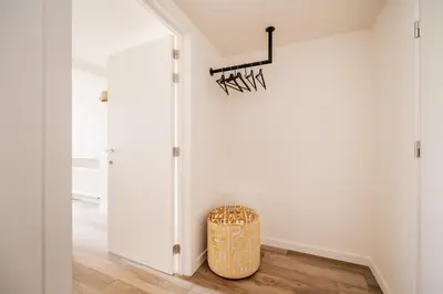 a room with a white wall and a stool at Heritage Suites Antwerp in Antwerp