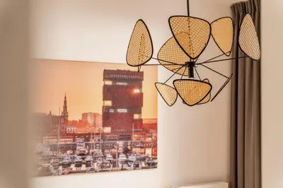 a chandelier hanging on a wall next to a window at Heritage Suites Antwerp in Antwerp
