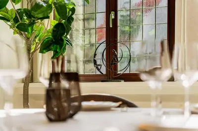 a table with a vase with a plant and a window at Heritage Suites Antwerp in Antwerp
