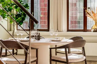 a table with glasses and chairs in a room with windows at Heritage Suites Antwerp in Antwerp