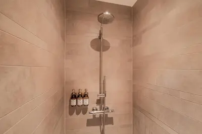 a bathroom with a shower with wine bottles at Heritage Suites Antwerp in Antwerp
