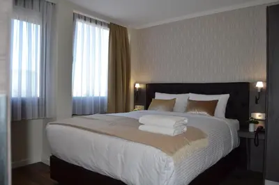 a bedroom with a large bed with white sheets and pillows at The Helmet Hotel in Brussels
