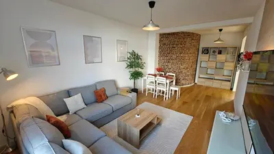 a living room with a couch and a table at Highgarden - warm & cozy in Brussels