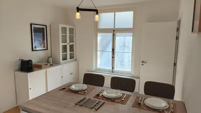 a dining room with a table and chairs and a window at Highgarden - warm & cozy in Brussels