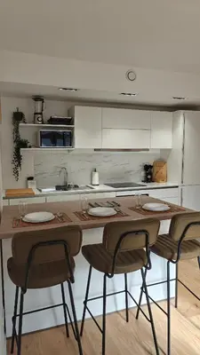 a kitchen with a wooden table with chairs and a sink at Highgarden - warm & cozy in Brussels
