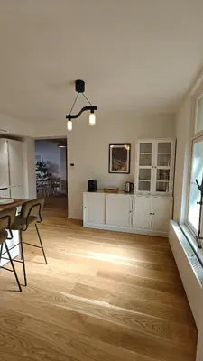 a kitchen and living room with a table and chairs at Highgarden - warm & cozy in Brussels