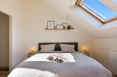 a bedroom with a large white bed with a window at Stylish 1BR close to KMSKA in Antwerp