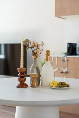 a table with bottles and glasses and a plate of food at Stylish 1BR close to KMSKA in Antwerp