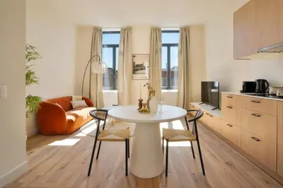 a kitchen and living room with a white table and chairs at Stylish 1BR close to KMSKA in Antwerp