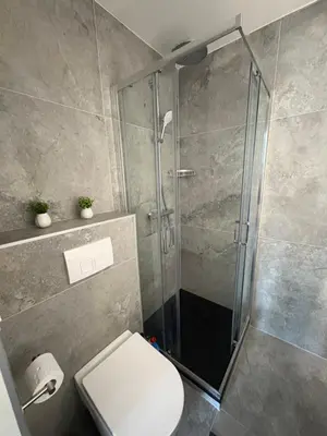 a bathroom with a glass shower with a toilet at Cozy Loft Grimbergen in Grimbergen