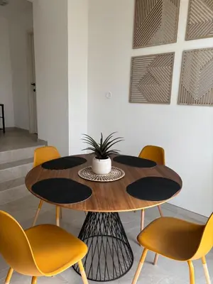 a dining room with a wooden table and yellow chairs at Cozy Loft Grimbergen in Grimbergen