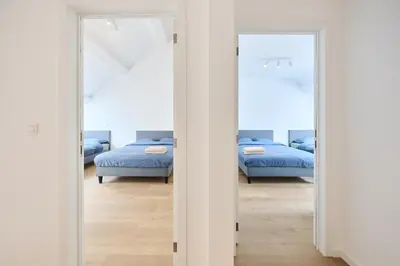 a bedroom with two beds and two mirrors at Toison d'Or in Brussels