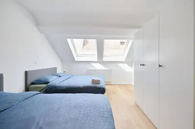 a bedroom with two beds and a window at Toison d'Or in Brussels