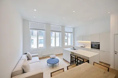 a kitchen and living room with a couch and a table at Toison d'Or in Brussels