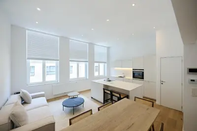 a kitchen and living room with a table and a couch at Toison d'Or in Brussels