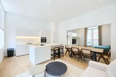 a kitchen and living room with a table and chairs at Toison d'Or in Brussels